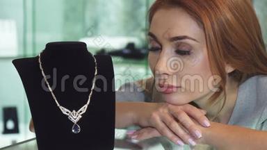 悲伤的女人在商店里摆着一条昂贵的<strong>钻石项链</strong>